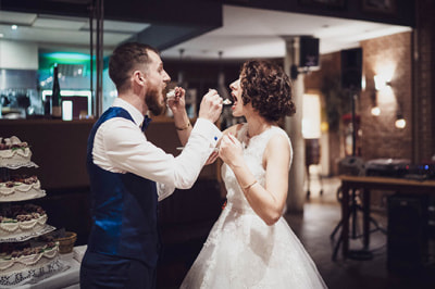 Hochzeitsfotos klassisch vs. natürlich - Empfang Braut und Bräutigam essen Hochzeitstorte