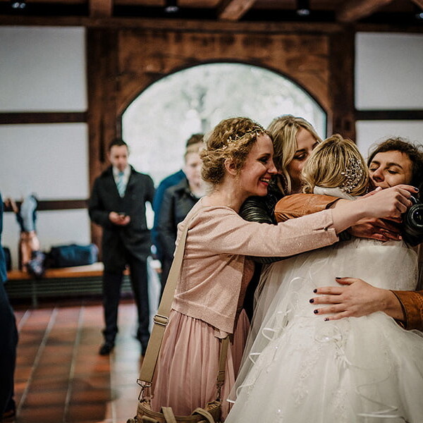 Wedding_photography_after_the_ceremony_friends_hugging_bride